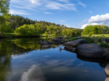 Nehrin ortasındaki bir kayanın üzerinde duran bir adam..