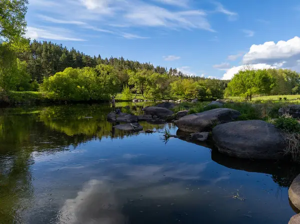 Nehrin ortasındaki bir kayanın üzerinde duran bir adam..