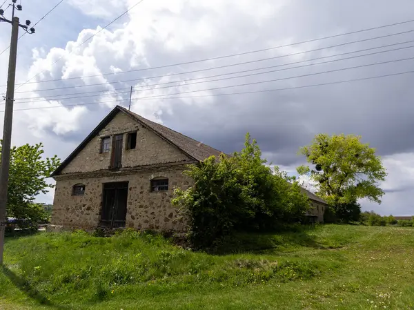 Çimenli bir arazinin ortasında duran eski bir taş bina..