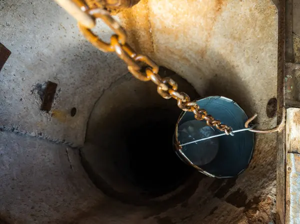 Kanalizasyona zincirlenmiş metal bir kova..