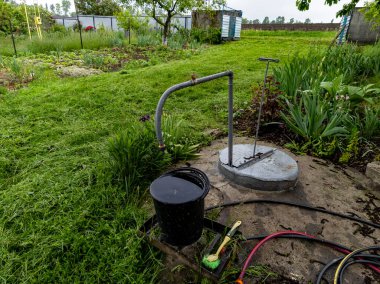 Ortasında su pompası olan bir bahçe..