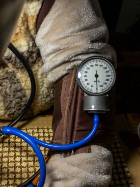 Elinde tansiyon ölçer tutan biri..