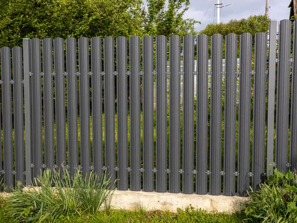 Çimenli bir alanın ortasında metal bir çit..