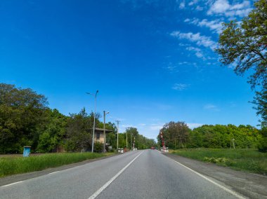 Demiryolu geçidi ve bariyeri olan yol.