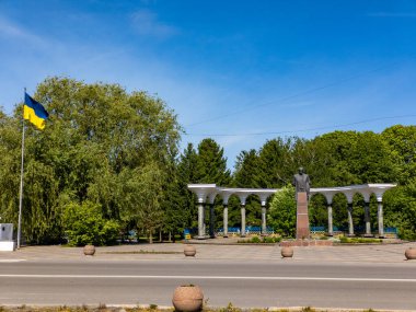 Parkın ortasında havada bir Ukrayna bayrağı dalgalanan Taras Shevchenko anıtı.