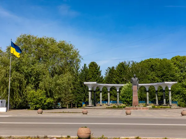 Parkın ortasında havada bir Ukrayna bayrağı dalgalanan Taras Shevchenko anıtı.