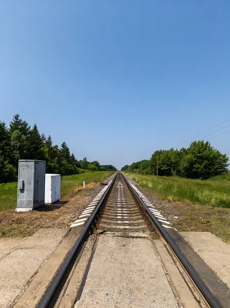 Çimenli bir arazinin yanındaki tren yolu..