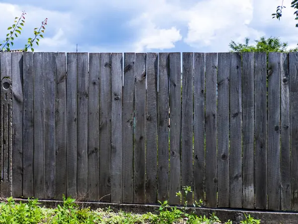 Çimenli bir alanın ortasında ahşap bir çit..