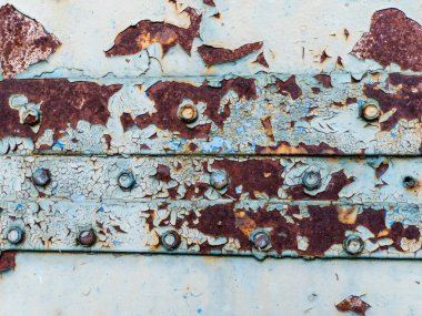 Paslı metal bir yüzeye yakın çekim ve soyulmuş boya..
