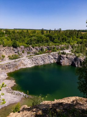 Etrafı ağaçlar ve taşlarla çevrili taşlı granit ocağı..