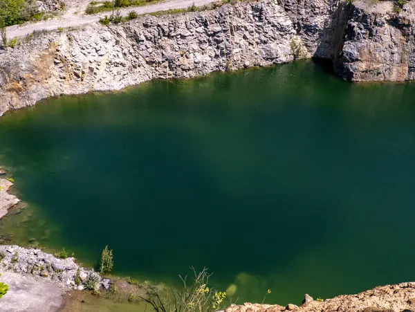 Kayalar ve ağaçlarla çevrili büyük bir su kütlesi..