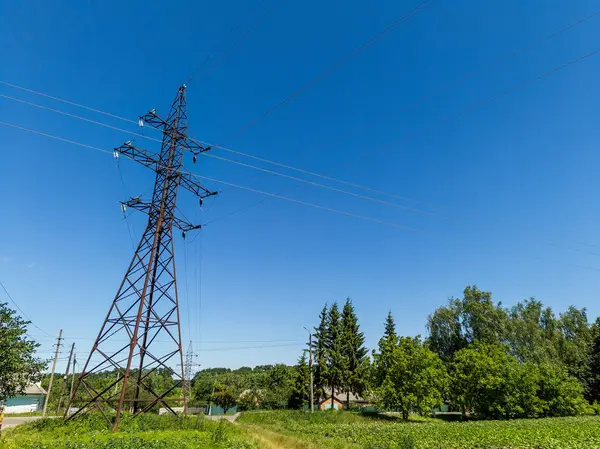 Yeşil çimlerin ortasındaki bir elektrik hattı..
