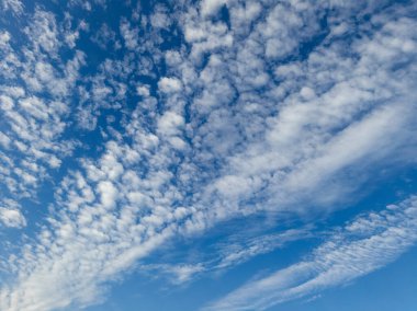 Ortasında beyaz bulutlar olan mavi bir gökyüzü..