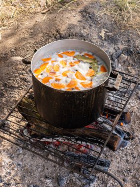Izgaranın tepesinde yemek dolu bir tencere..