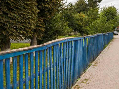 Yolun kenarında, kaldırımın yanında mavi bir çit..