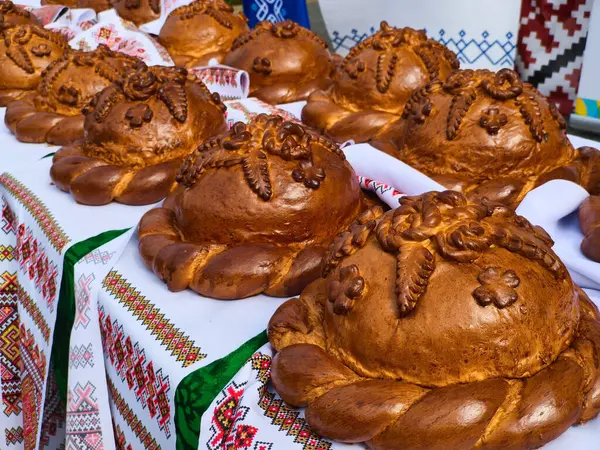 Masa örtüsünün üstünde bir sürü ekmek olan bir masa..