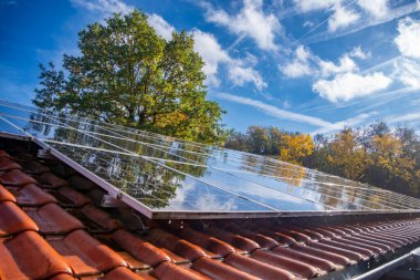 Wet photovoltaic modules in front of blue and cloudy autumn sky. High quality photo clipart