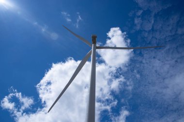 Rüzgar türbinleri mavi gökyüzünün arka planında alternatif enerji üretiyor. Yüksek kalite fotoğraf