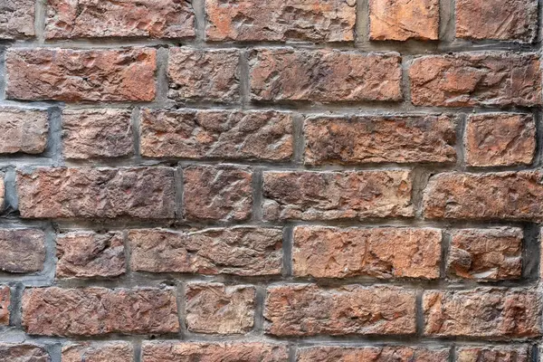 Bu, çok sayıda tuğlanın birbirine yakın sıralandığı, dokularını ve renklerini gösteren bir duvar.