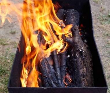 Yanan kırmızı kıvılcımlar ateşten uçar. Işıl ışıl yanan kömür ve yakacak odunları olan ızgara ızgarası.
