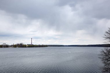 Enerji santralinin manzarası doğanın arka planına karşı. Bir su kütlesinin arka planında elektrik santralinin görüntüsü