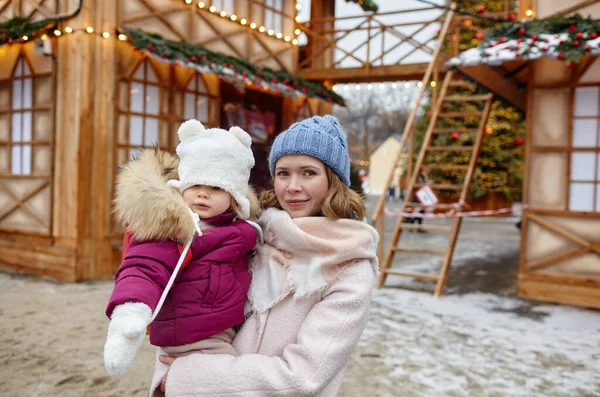 stock image Mother and daughter are walking around the city on Christmas and New Year holidays. Parent and little child having fun outdoors