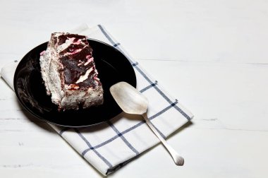 Tabakta bir dilim lezzetli çikolatalı pasta var. Ahşap arka planda lezzetli bir tatlı, yakın planda.