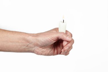 Erkeklerin elinde izole edilmiş beyaz bir arkaplan mumu var. Elinde yanan mum tutan adam, yaklaş.