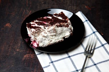 Tabakta bir dilim lezzetli çikolatalı pasta var. Ahşap arka planda lezzetli bir tatlı, yakın planda.