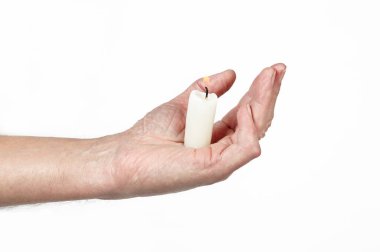 Erkeklerin elinde izole edilmiş beyaz bir arkaplan mumu var. Elinde yanan mum tutan adam, yaklaş.