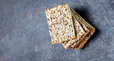 Tohumlu çıtır ekmek. Tahta zeminde çıtır çıtır çıtır çıtır ekmek. Sağlıklı atıştırmalık: mısır gevreği, çoklu tahıllı keten tohumu, ayçiçeği tohumlu protein ekmeği. Üst görünüm