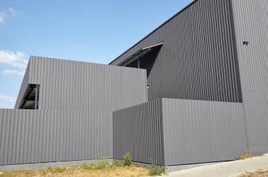 Oluklu çelik depo veya mavi gökyüzüne karşı fabrika sanayi binası. Mimarlık. Metal doku