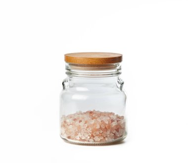 Himalaya pembe tuzu cam kavanozda beyaz arka planda izole edilmiş. Gurme tuzu - kırmızı himalaya çeşidi