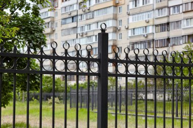 Şehir parkında metal çitler. Korunmak için dekoratif siyah demir parmaklıklar, kapatın.