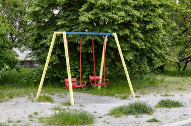 Bahçede çocuksuz renkli salıncaklar. Kentsel mahalle çocukluk kavramı
