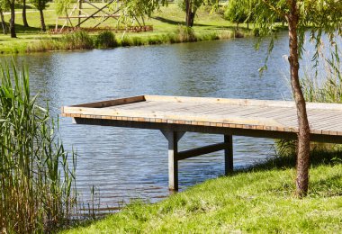 Avrupa 'nın Kyiv kentindeki nehir dolgusu üzerinde ahşap gözlem güvertesi olan dinlenme alanı. Şehir parkında dinlenecek bir yer.