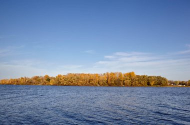 Güzel sonbahar doğa manzarası. Avrupa 'nın başkenti Kyiv' de nehir kenarındaki sık ağaçlarla mavi gökyüzü manzarası