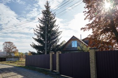 Güzel Avrupa sonbahar kırsal manzarası. Köy evleri ve çitler mavi gökyüzü arka planına karşı kümülüs bulutlu