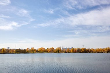 Güzel Avrupa sonbaharı şehir manzarası. Avrupa 'nın başkenti Kyiv' de nehir kenarındaki sık ağaçlarla mavi gökyüzü manzarası