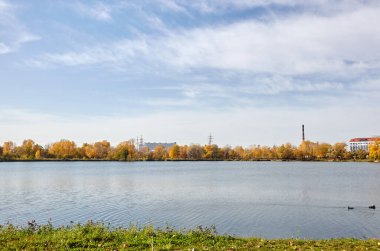 Güzel Avrupa sonbaharı şehir manzarası. Avrupa 'nın başkenti Kyiv' de nehir kenarındaki sık ağaçlarla mavi gökyüzü manzarası