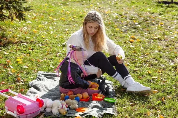 Merhaba Ekim. Anne ve kızı sonbahar şehir parkında yürüyorlar. Ebeveyn ve küçük çocuk dışarıda eğleniyor.