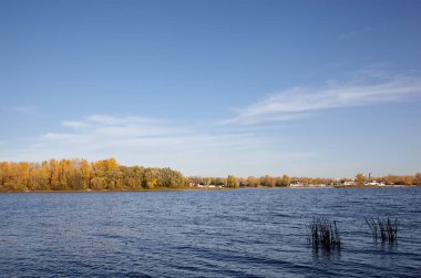 Güzel sonbahar doğa manzarası. Avrupa 'nın başkenti Kyiv' de nehir kenarındaki sık ağaçlarla mavi gökyüzü manzarası