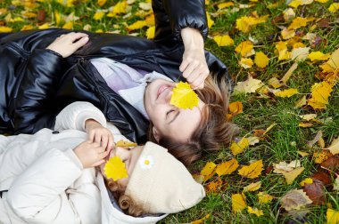 Merhaba Ekim. Anne ve kızı sonbahar şehir parkında yürüyorlar. Ebeveyn ve küçük çocuk dışarıda eğleniyor.