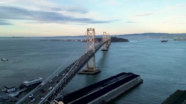 Şehir merkezindeki gökdelenleri keşfetmek için San Francisco Bay Köprüsü 'nün etrafında pembe gün ışığı altında uçan sinemacılar. San Francisco USA, asma köprü simgesi Kaliforniya. Çekim ayarlanıyor