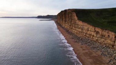 West Bay Cliffs, West Bay, Jurassic Coast, Dorset, İngiltere 'nin en iyi sinematik manzarası. 4K İHA görüntüleri.