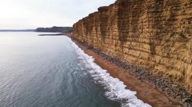 West Bay Cliffs, West Bay, Jurassic Coast, Dorset, İngiltere 'nin en iyi sinematik manzarası. 4K İHA görüntüleri.