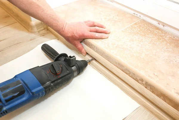 stock image Installation of doorstep indoors. Drill in hands. Renovation works in the flat.