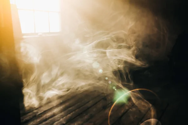 Sunshine window reflection on the wooden floor. Heavy smoke in loft design studio. Cinematic photo.