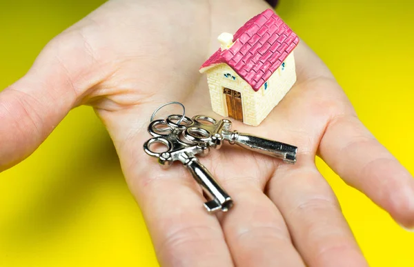 House and keys on woman hands. Buying and renting real estate. Bank credit for property. Save money.
