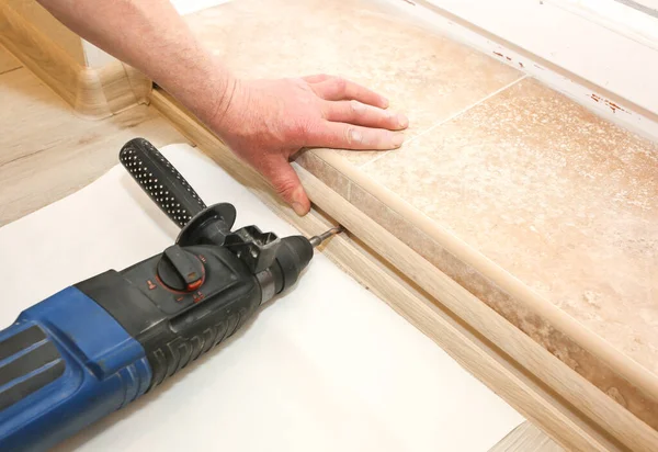 stock image Installation of doorstep indoors. Drill in hands. Renovation works in the flat.